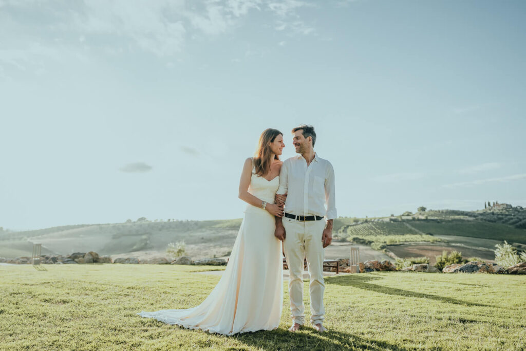 Happy couple celebrating their anniversary embracing at One Belvedere Tuscany, an eco luxury villa retreat surrounded by rolling Chianti Classico vineyards and golden Tuscan hills at sunset