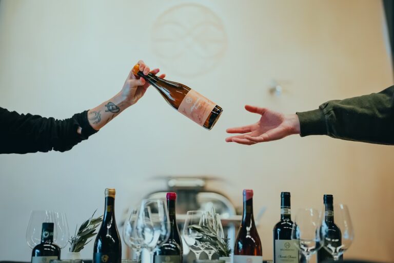 Guests exchanging a Belvedere1 wine bottle during a tasting experience at Workshops at One Belvedere Tuscany