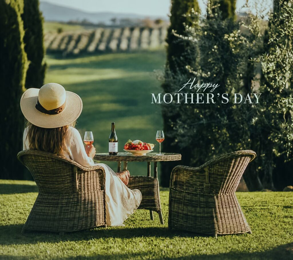 Woman seated on a garden terrace in Tuscany enjoying wine with vineyard views and Mother’s Day setting