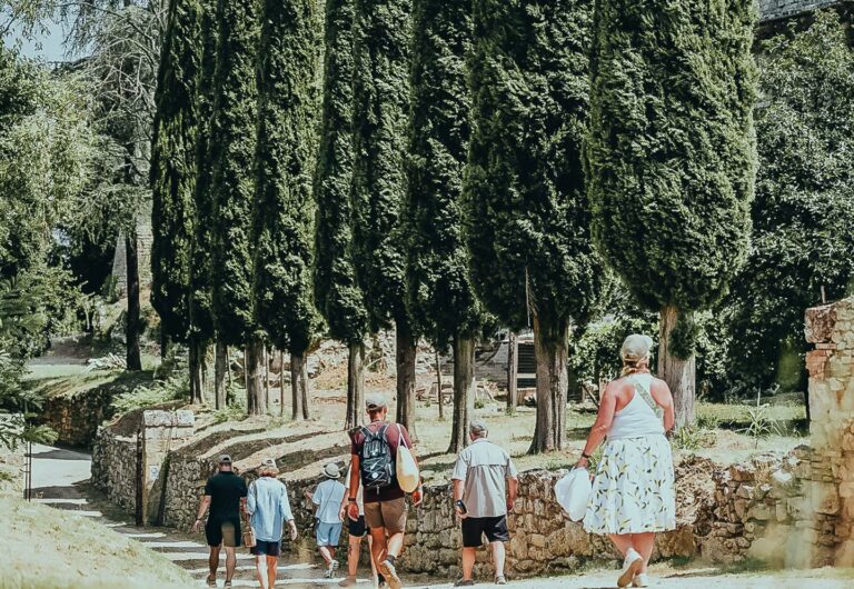 Guests enjoying outdoor adventures in Tuscany while walking along a cypress-lined path at One Belvedere Tuscany.