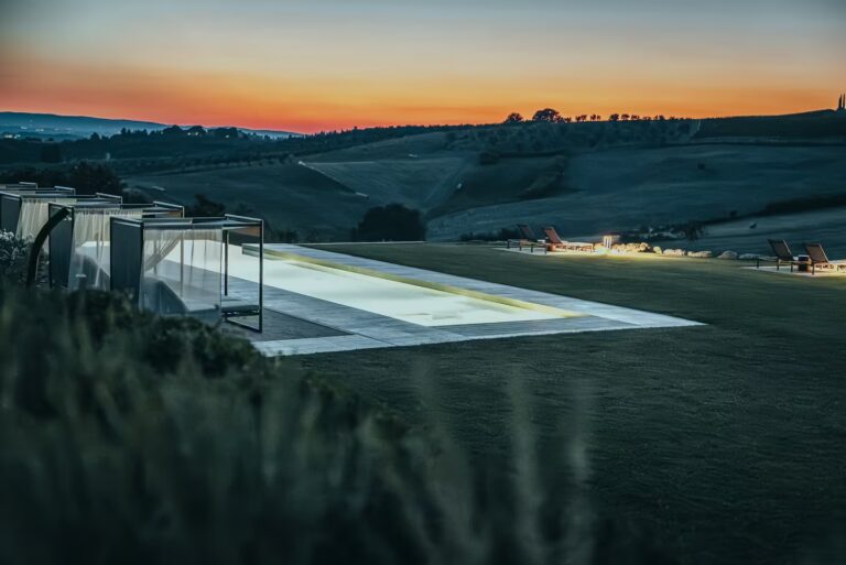Sunrise vs Sunset in Tuscany at One Belvedere Tuscany, featuring an illuminated infinity pool overlooking the rolling hills of Chianti Classico at dusk.