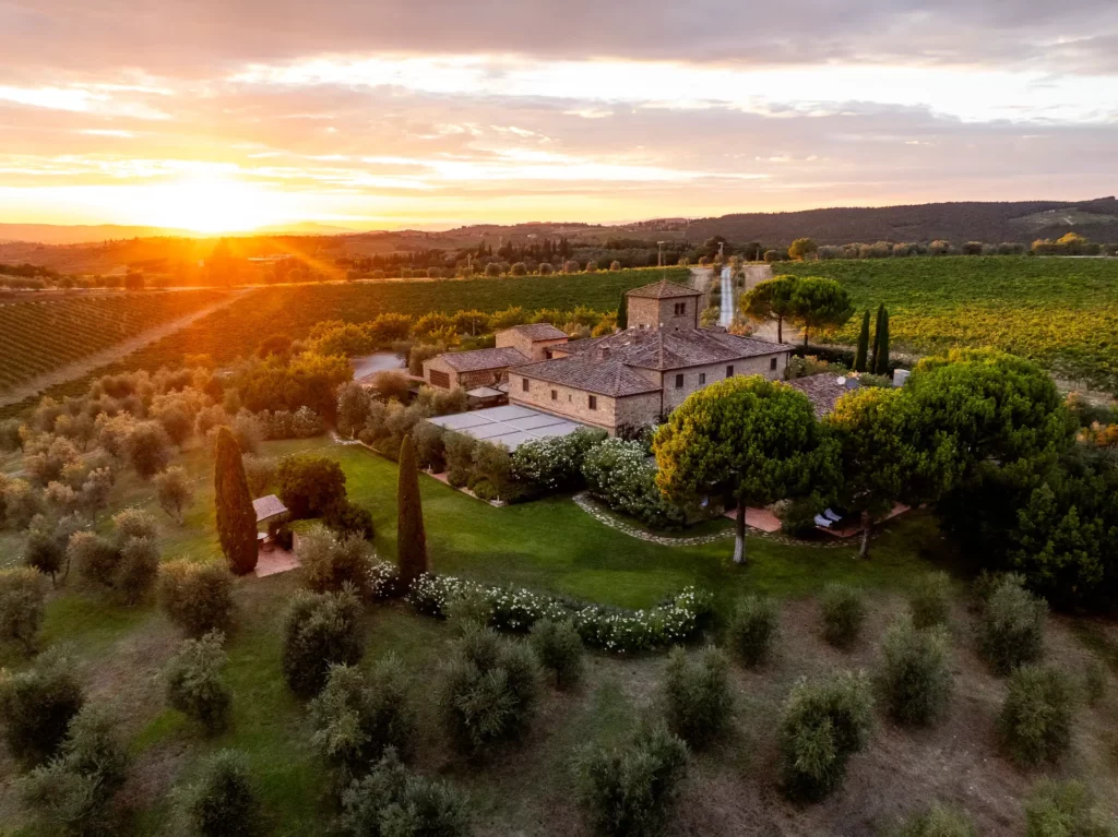 Aerial view of Locanda Le Piazze estate at sunset, surrounded by the rolling hills of Chianti, Tuscany